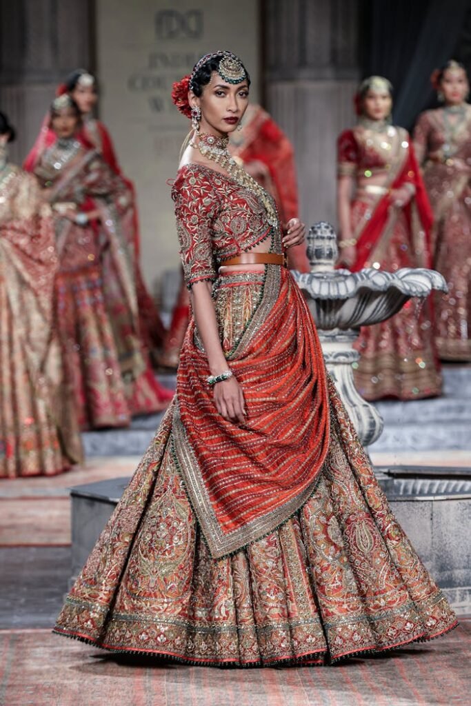 pexels photo 13197697 Model in traditional Indian bridal attire on a fashion runway, showcasing elegance and cultural heritage.