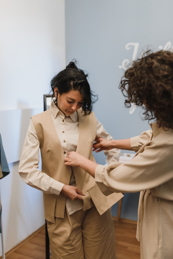 why-choose-us A boutique tailor adjusting a vest for a young customer inside a shop.